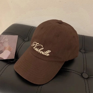 Brown baseball cap with Nashville embroidery on textured leather surface