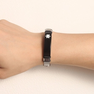 Detail of adjustable silver mesh medical alert bracelet with black ID plate on wrist
