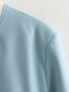 Close-up of light blue twill fabric texture and stitching on the bomber jacket collar