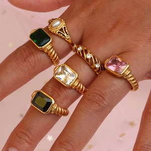 Goldene Croissant Ringe mit bunten Edelsteinen und Perlen an der Hand des Models