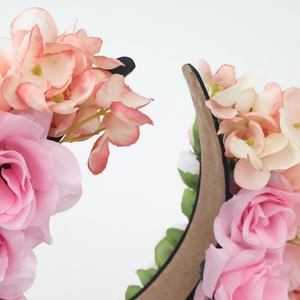 Close-up of pink and peach fabric artificial flowers on a traditional floral headband