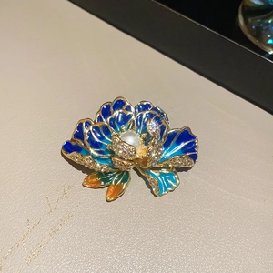 Macro detail of French style 3D flower brooch with blue petals and center pearl inlay