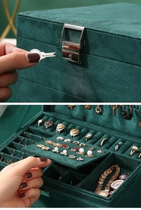 Detailed view of the dark green velvet jewelry box with metal lock and multi-layer storage