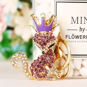 Macro shot of fox keychain with purple rhinestones and golden crown detail