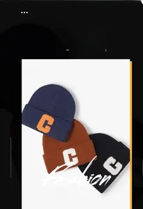Trois bonnets en maille épaisse en bleu, caramel et noir avec broderie de la lettre C
