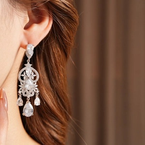 Close-up of vintage silver tassel earrings with zircon water-drop and heart pendant detail