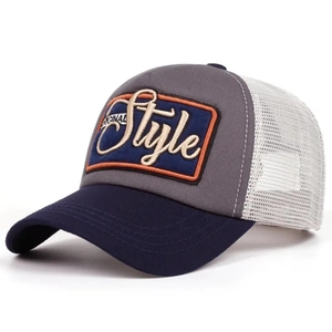 Detail of 3D embroidered patch and white mesh panels on a two-tone trucker baseball cap
