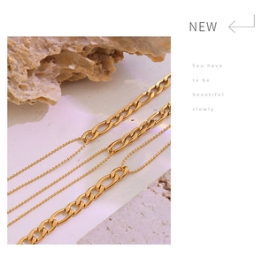 Detailed shot of double-layered gold necklace on natural rock with sleek industrial design