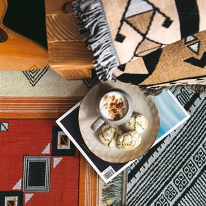Close-up of geometric bohemian woven blanket texture with colorful ethnic patterns and tassels