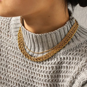 Layered 18k gold plated stainless steel twist chain necklace worn on a grey sweater