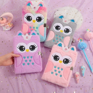 Flat lay of colorful plush owl notebooks with heart locks and stationery on purple background