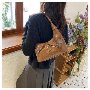 Brown retro underarm bag featuring bow details and metallic studs on glossy leather