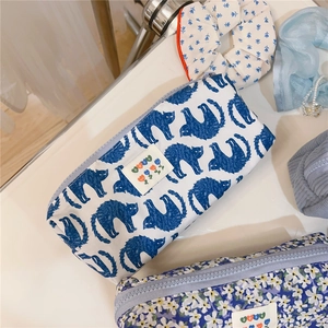 Close-up of floral and blue cat pattern canvas pouches with decorative ribbons and pearls