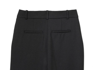 Detail of high-waist black trousers showing belt loops and back welt pocket craftsmanship