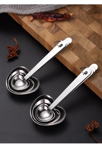 Detail of heart-shaped stainless steel measuring spoons with engraved A Pinch of Joy text