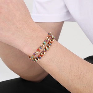 Dettaglio del bracciale a catena cubana dorata con smalto colorato sul polso