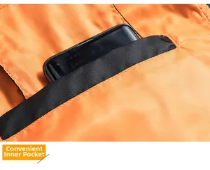 Detailansicht der funktionalen Innentasche an der orangefarbenen Fliegerjacke aus Nylon