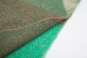 Close-up of green camouflage faux mohair fabric texture with thick brushed fiber details