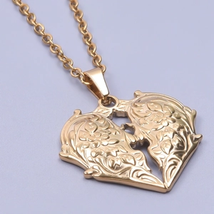 Gros plan d'un pendentif cœur en or 18 carats avec gravures florales et texture métal