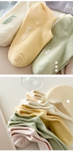 Detail of pastel cotton socks with ribbed cuffs and hello text in assorted colors