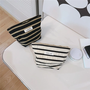 Close-up of minimalist striped canvas makeup bags with 'simple wish' textile labels