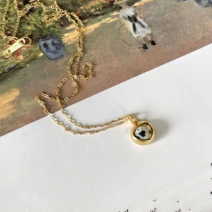 Macro shot of 925 sterling silver heart necklace with zebra stone inlay on art card