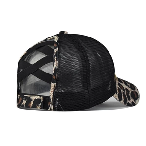 Detail view of the black criss-cross elastic ponytail hole on leopard print baseball cap
