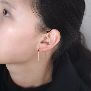 Detailed close-up of a s925 silver long rectangular zirconia tassel earring on model