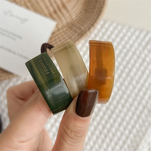 Three-piece acetate hair tie set in green, beige and amber with gold lettering