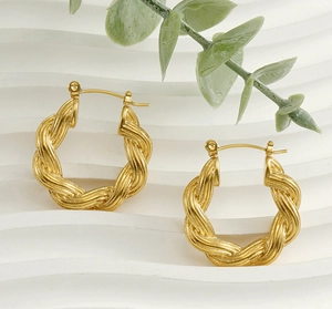 Vue détaillée des boucles d'oreilles créoles dorées torsadées au fini poli vintage
