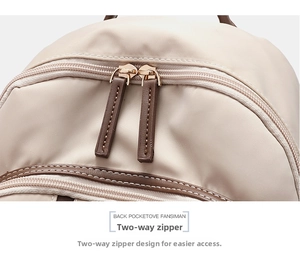 Primer plano de cremalleras dobles con tiradores de cuero en una mochila beige