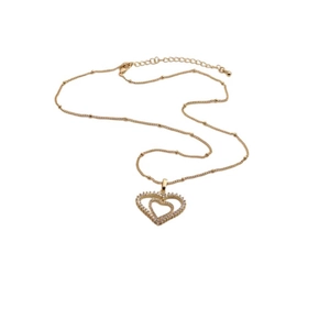 Macro view of gold heart pendant with cubic zirconia inlay on fine bead chain