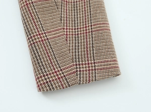 Close-up of houndstooth fabric sleeves showing fine texture and sewing detail on blazer