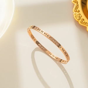 Rose gold Roman numeral bangle with rhinestones on an elegant mirrored background