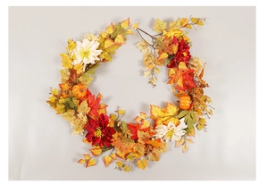 Detailed close-up of autumn wreath with maple leaves, pumpkins, and dahlias for decor