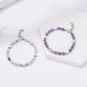 Detail of S925 sterling silver beads and pink stone bracelet on a white stone block