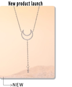 Detailed close-up of silver moon and star tassel necklace set with zircon stones