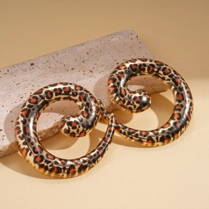 Detailed macro view of spiral leopard print earrings with a polished golden finish