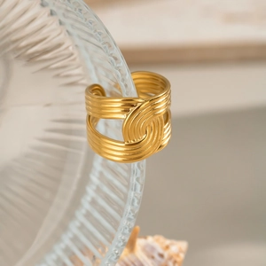 Detail of 18K gold textured wide open ring with overlapping curved wave design