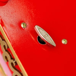 Détail d'une boîte à musique en bois rouge avec une clé de remontage dorée polie
