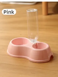 Distributeur automatique de croquettes et d'eau rose pour animaux sur sol en bois