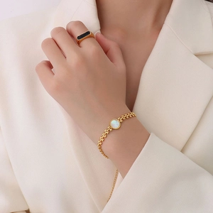 Elegant 18K gold wheat ear bracelet with white sea shell heart and black inset ring