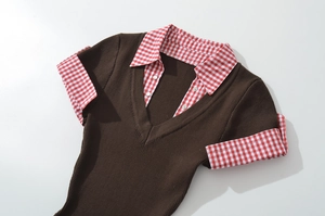 Detail view of brown rib-knit layered top with red and white plaid collar and V-neckline