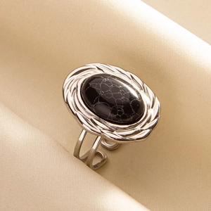 Macro shot of an adjustable vintage ring with black turquoise stone on silk fabric