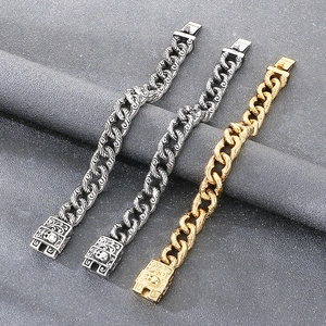 Detail of vintage gothic Cuban link bracelets featuring skull clasps and floral carvings