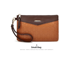 Detail of small fashion wristlet bag in brown tones with retro embossed link patterns
