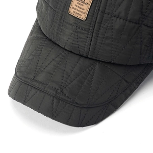 Detail of winter baseball cap with geometric quilted stitching and brown leather patch