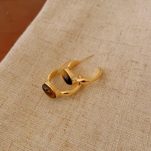 Detailed view of vintage gold hoop earrings featuring polished tiger's eye stone inlays.