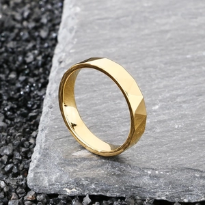 Dettaglio macro dell'anello in tungsteno dorato con design geometrico su pietra