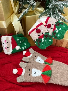 Close-up of thick coral fleece Christmas socks with festive 3D Santa and reindeer details